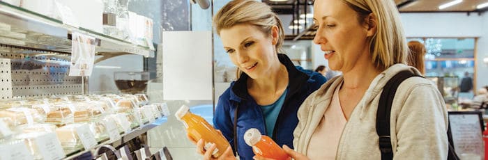 Women comparing antioxidant bevarages in a health cafe after working out.